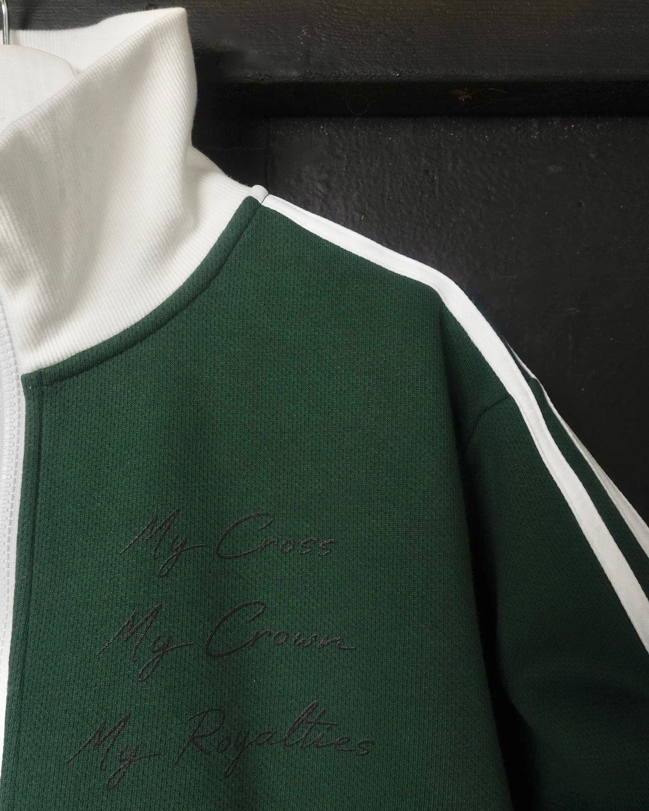 Green and white jacket with embroidered text on a black background