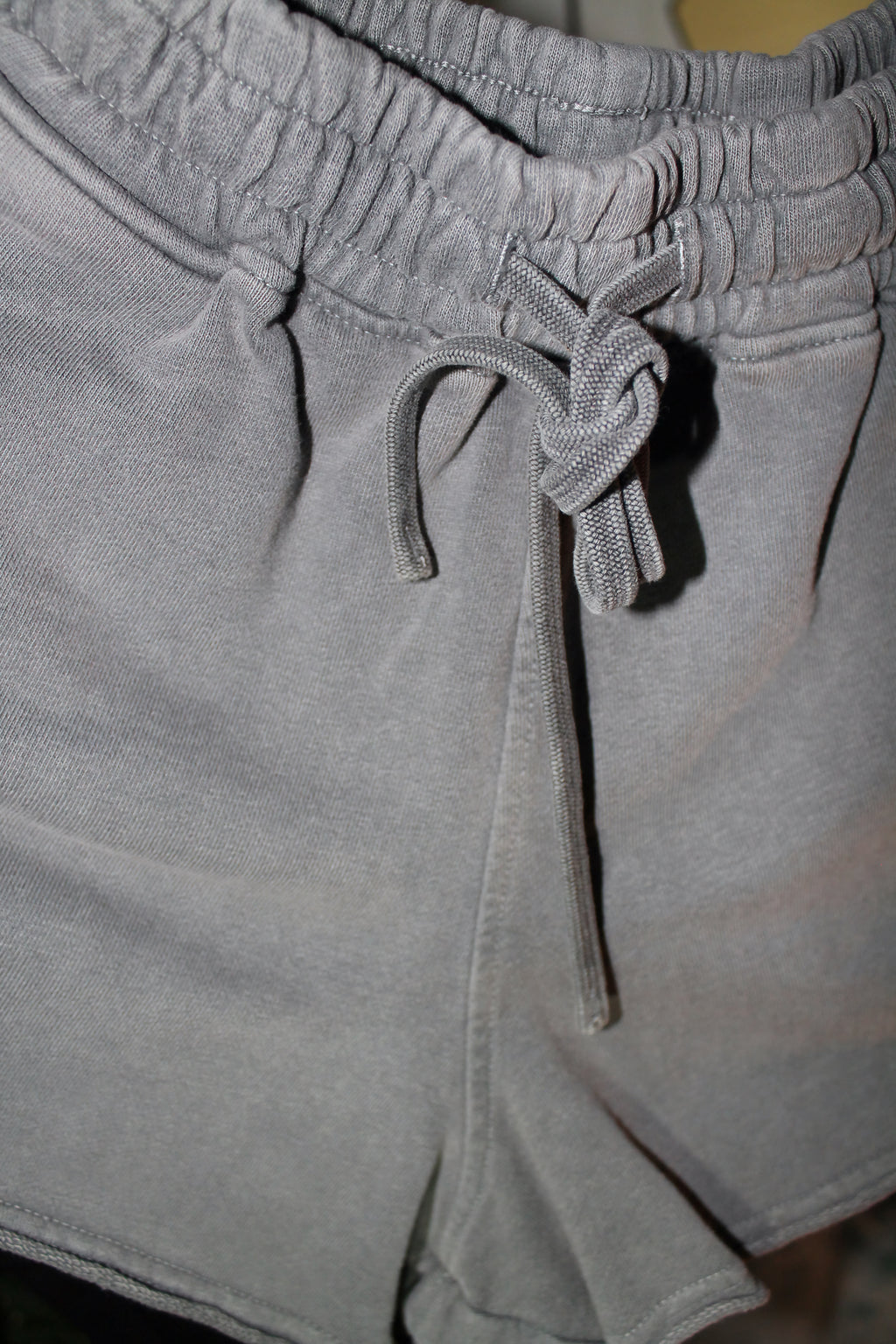 Close-up of gray shorts with a drawstring