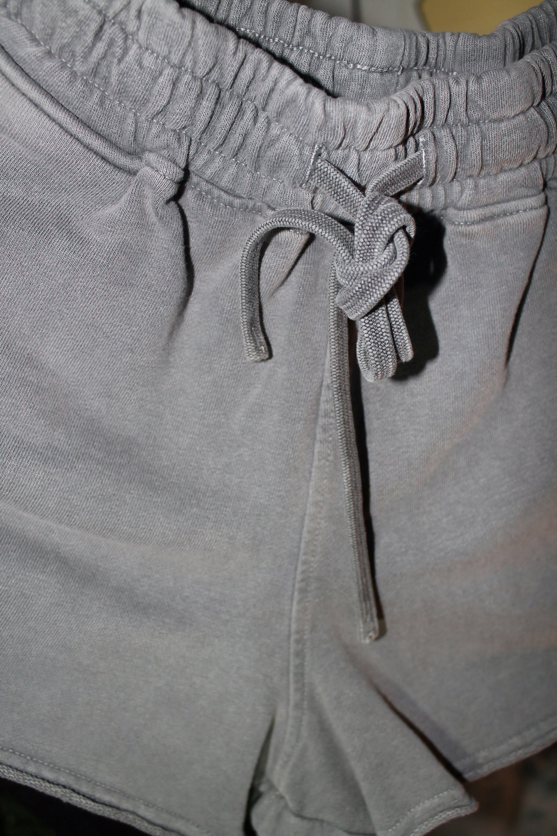 Close-up of gray shorts with a drawstring