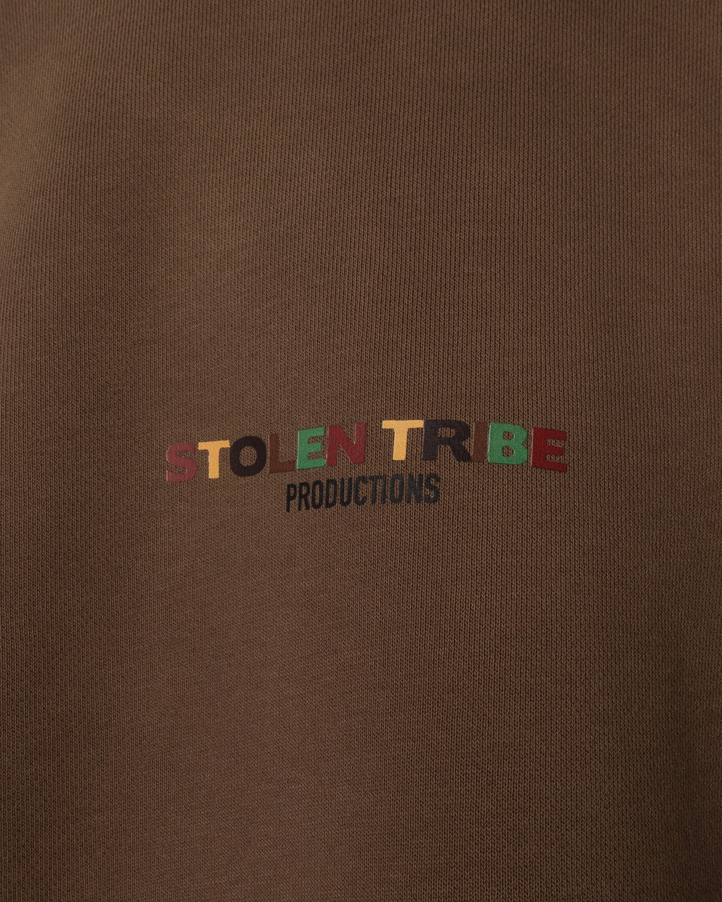 Brown sweatshirt with 'STOLEN TRIBE PRODUCTIONS' text in multicolor on a brown background