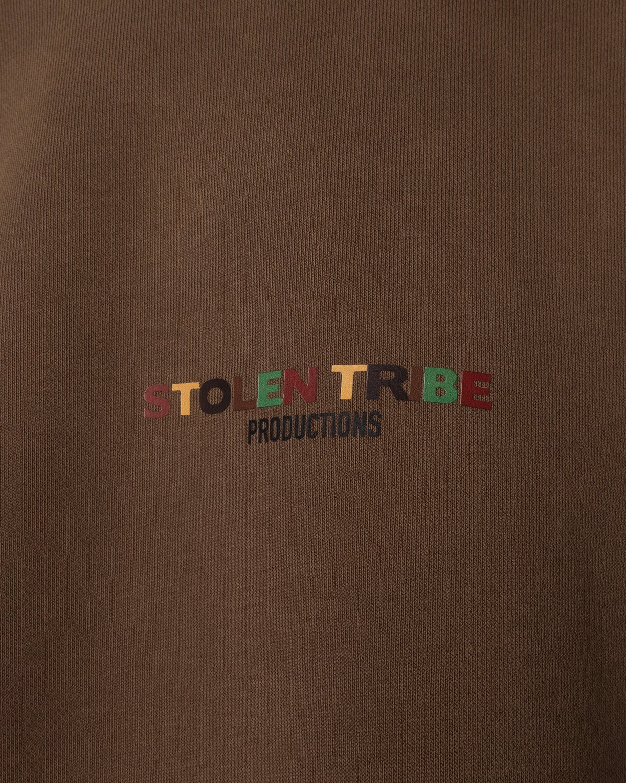 Brown sweatshirt with 'STOLEN TRIBE PRODUCTIONS' text in multicolor on a brown background
