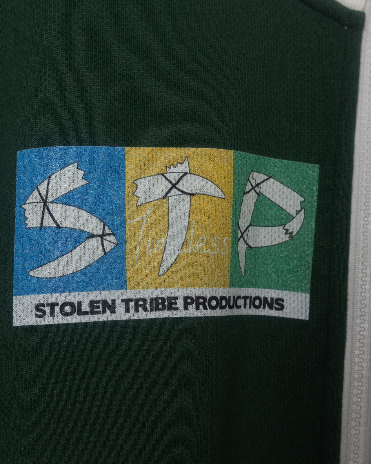 Logo of Stolen Tribe Productions on a dark green Track Jacket