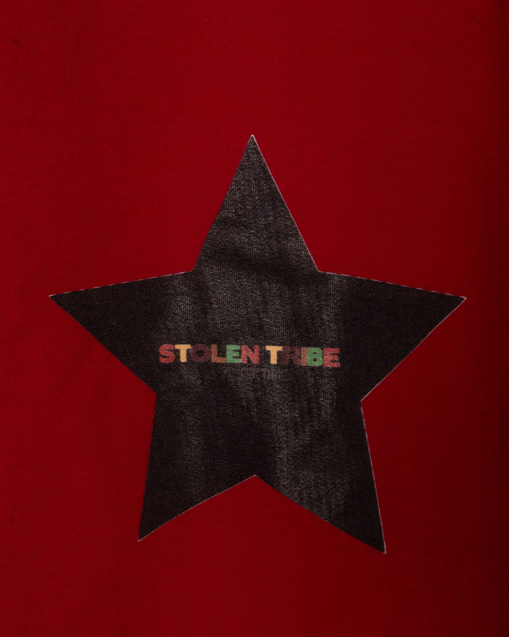 Black star-shaped patch with 'STOLEN TRIBE' text on a red background