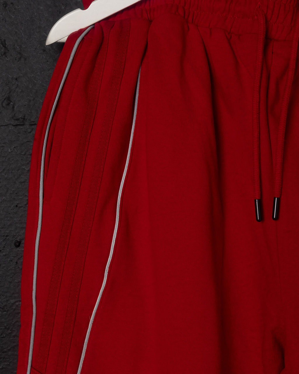 Red pants with white trim on a dark background