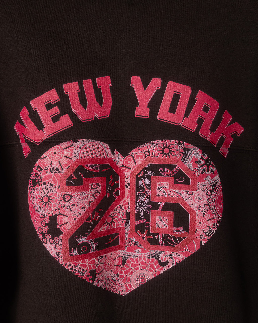 Black sweatshirt with pink 'New York 26' design on a dark background