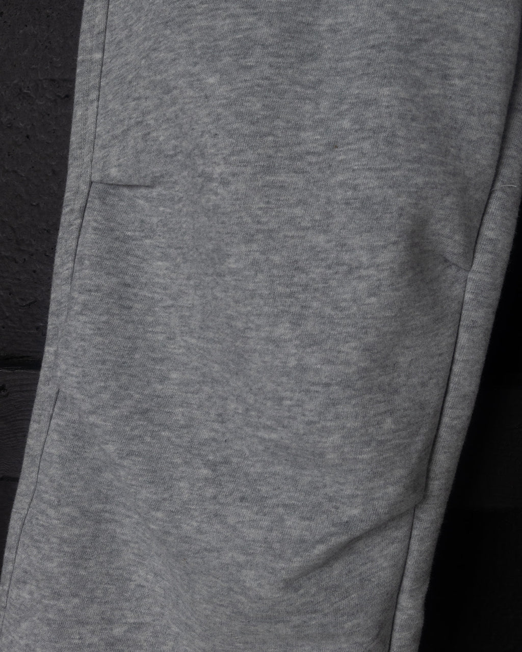 Close-up of gray sweatpants on a black background