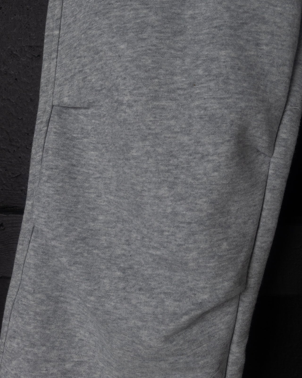 Close-up of gray sweatpants on a black background