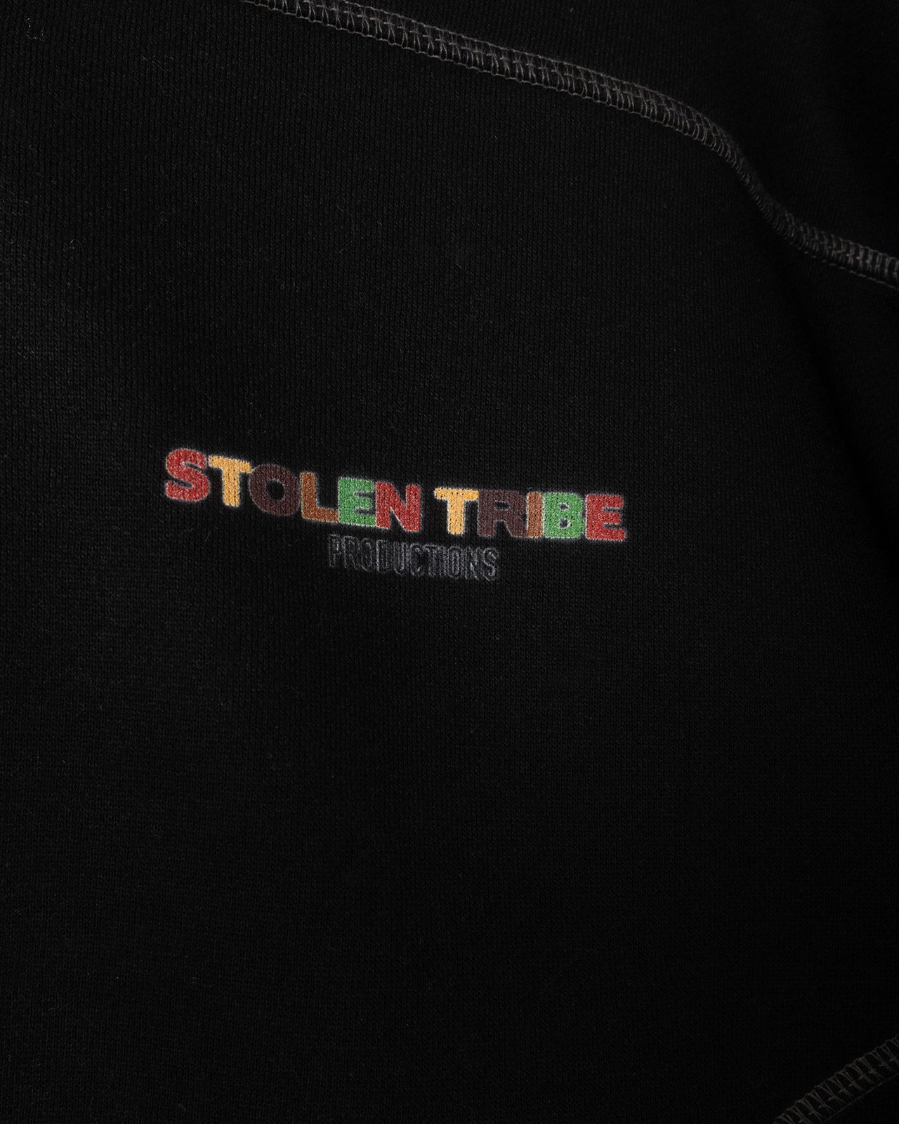 Embroidered 'Stolen Tribe Productions' logo on a black background