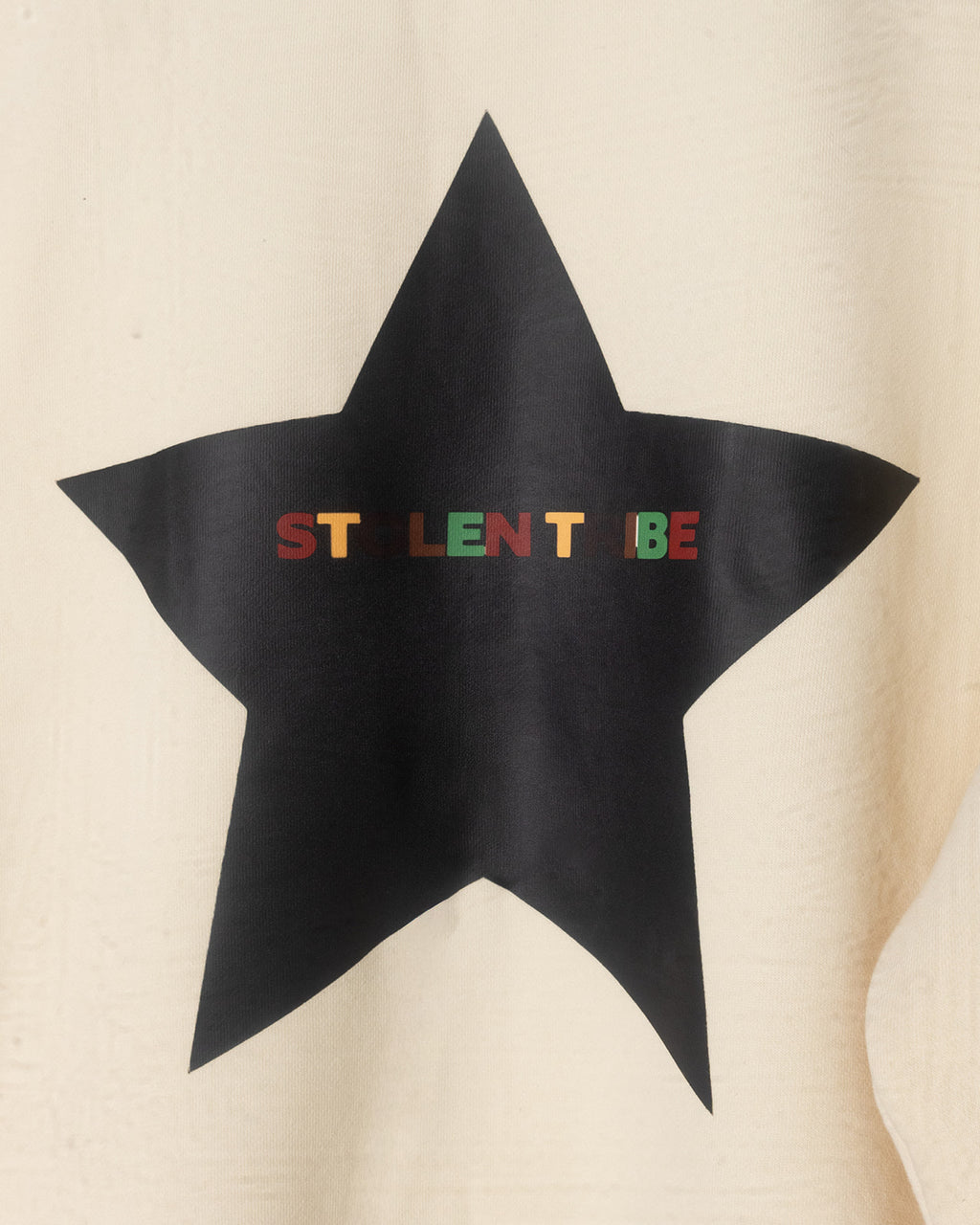 Black star-shaped object with colorful text on a beige background