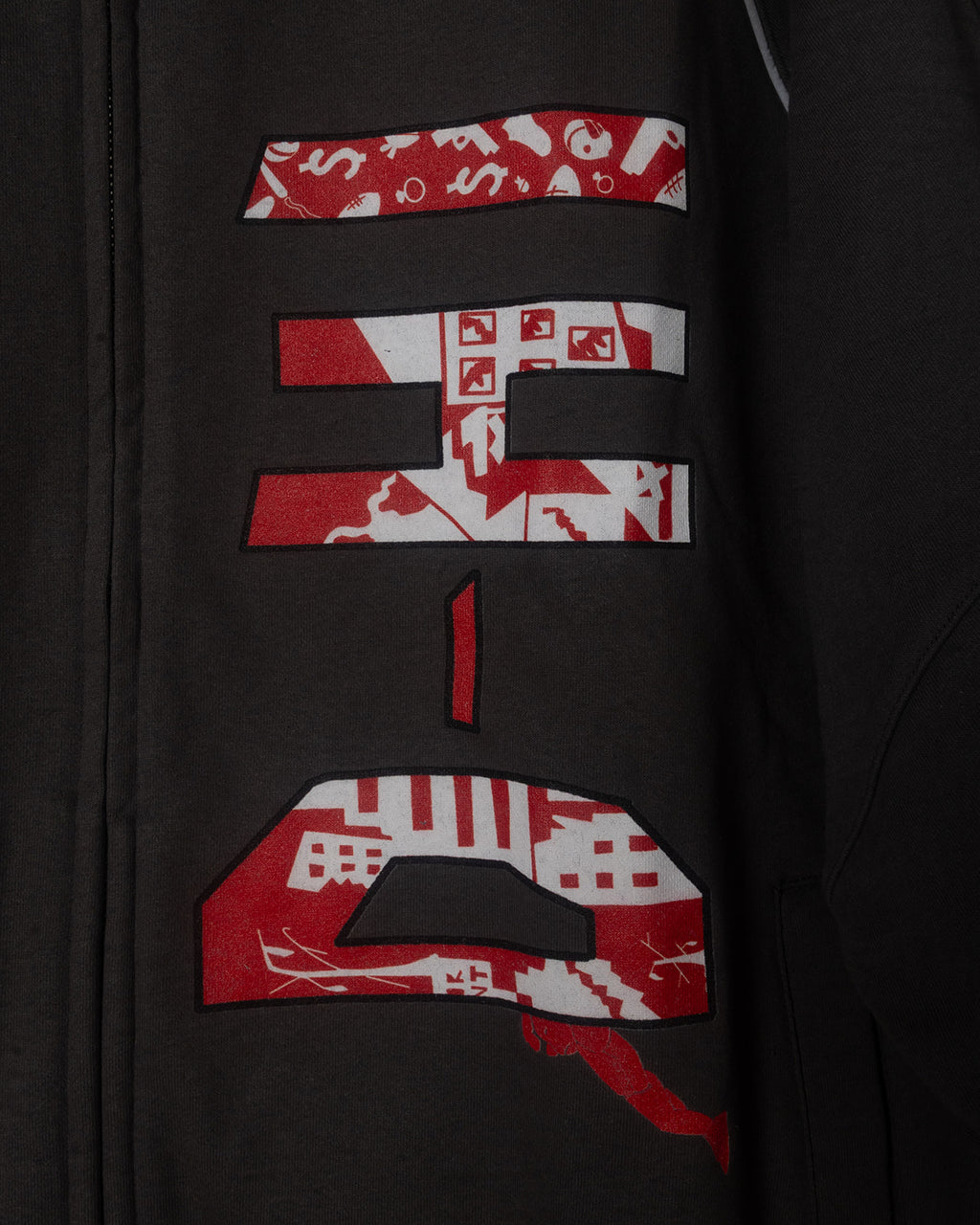 Gray jacket with red and white patterned text design on a dark background