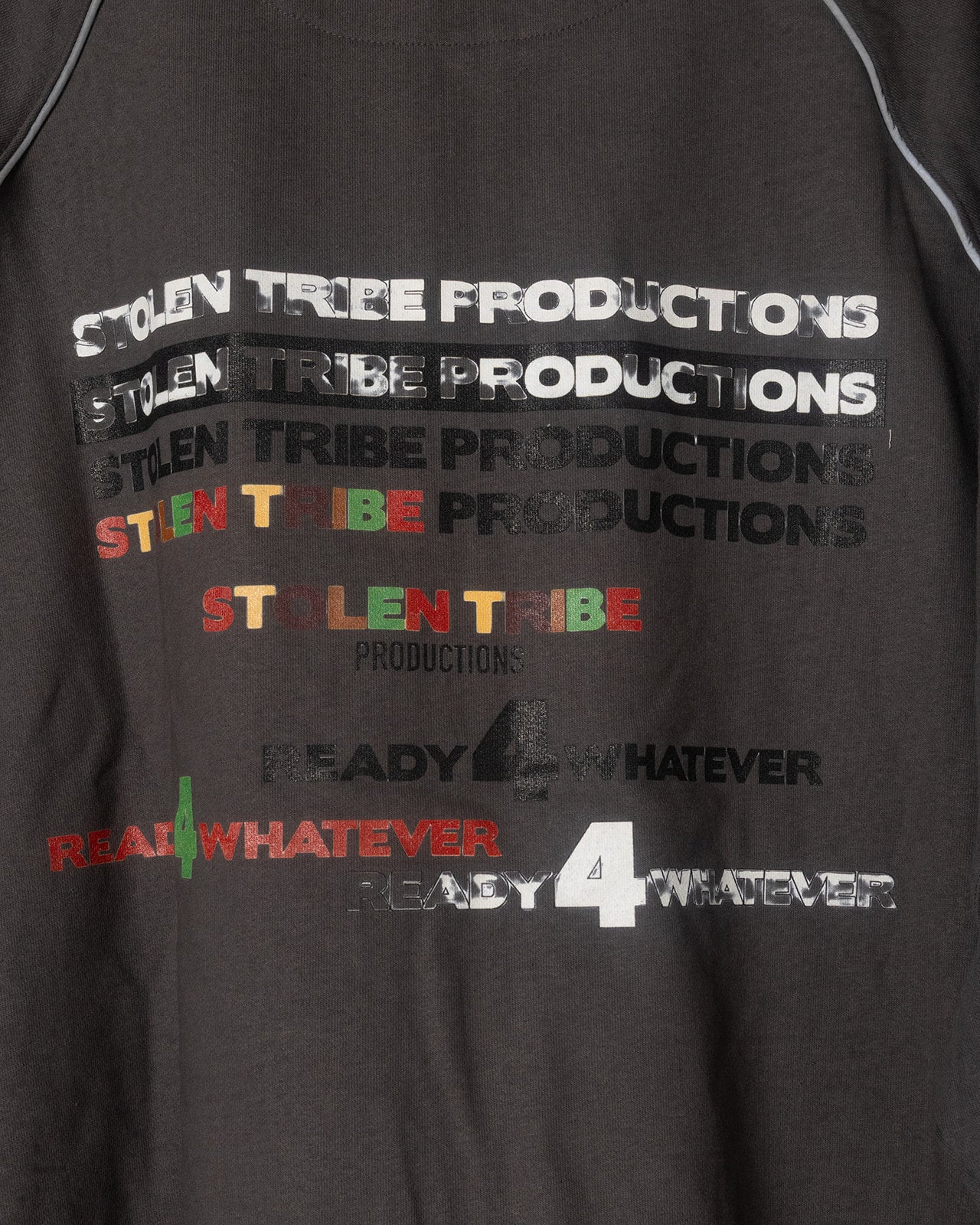 Gray jacket with 'Stolen Tribe Productions' text in various colors on a plain background