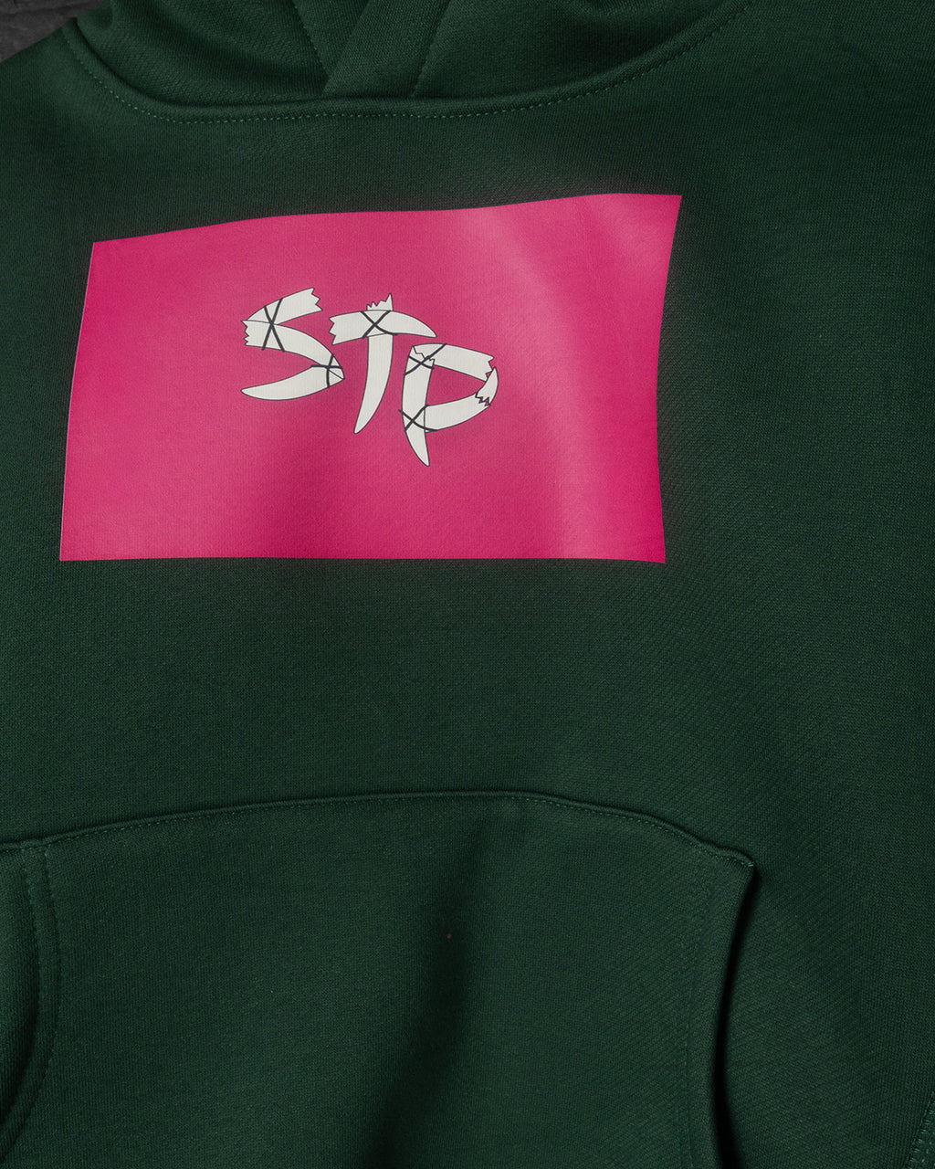 Green hoodie with a pink logo on the chest