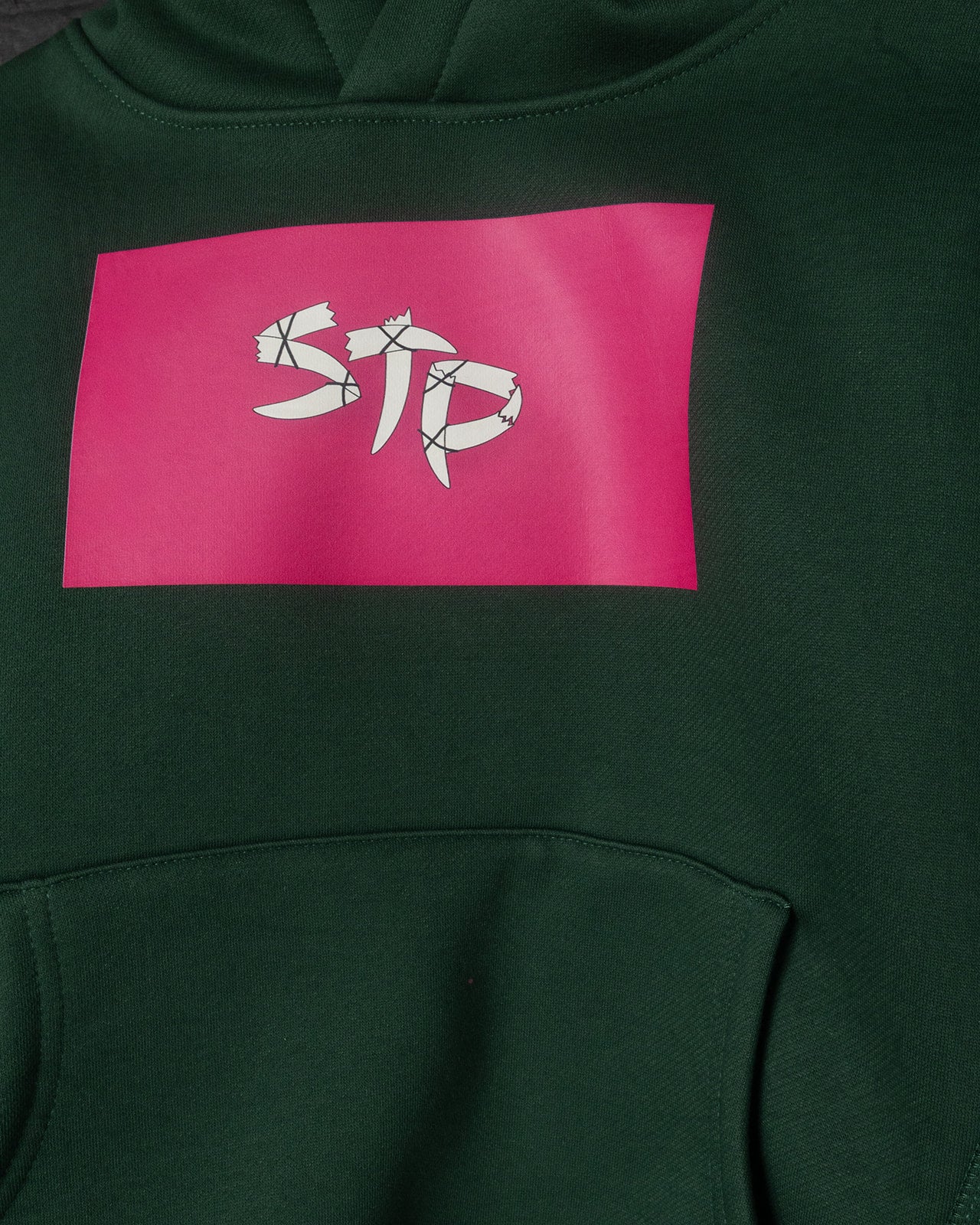 Green hoodie with a pink logo on the chest