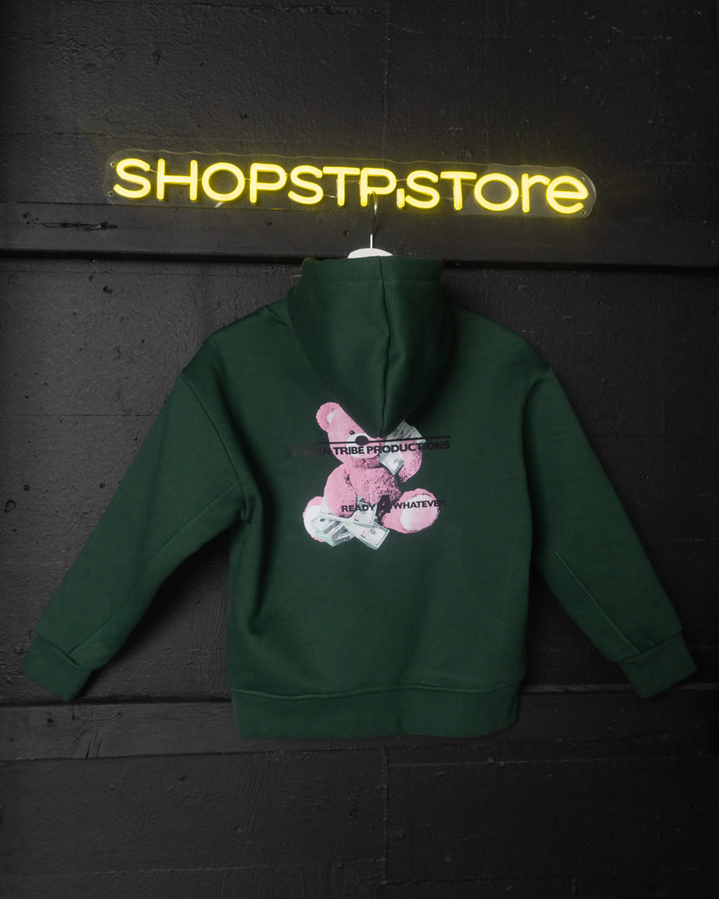 Green hoodie with a graphic design on the back, displayed against a dark background with 'SHOPSTP.STORE' neon sign.