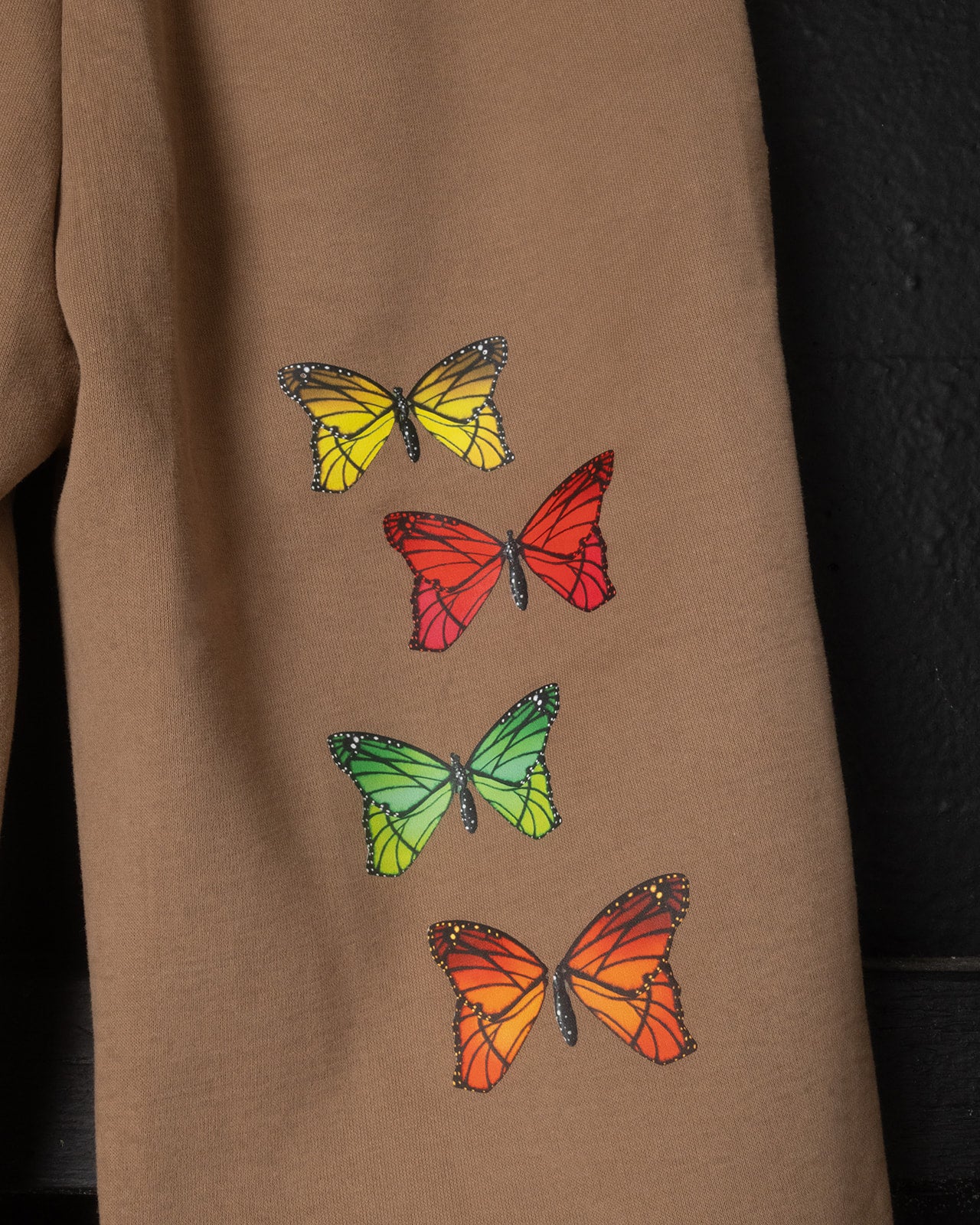 Brown fabric with colorful butterfly designs on a dark background