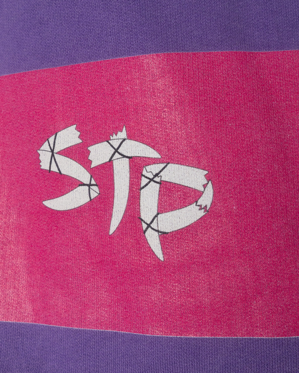 Close-up of a fabric with a logo on a purple and pink background