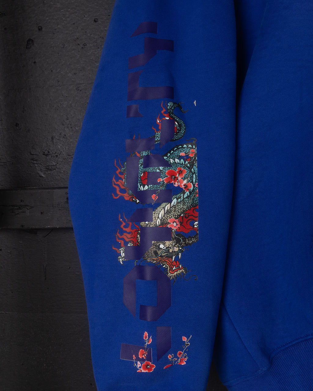 Blue hoodie with intricate design on a dark background