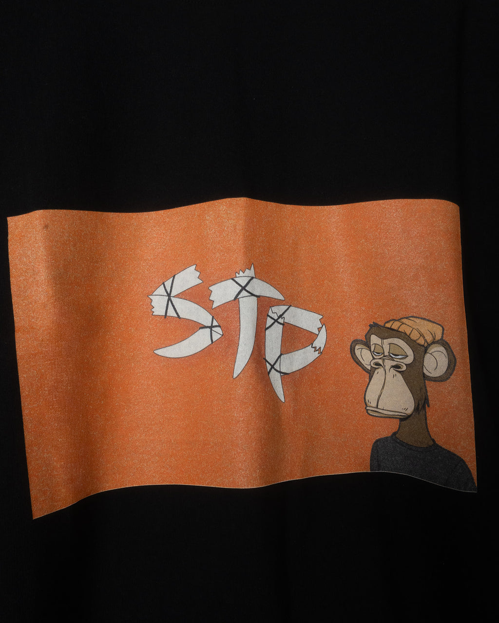 Orange STP flag with 'STP' text and cartoon monkey on a black background