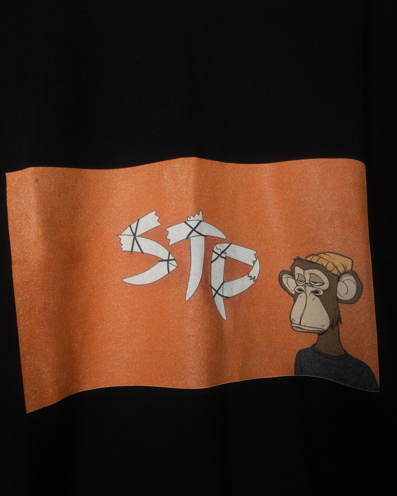 Orange STP flag with 'STP' text and cartoon monkey on a black background