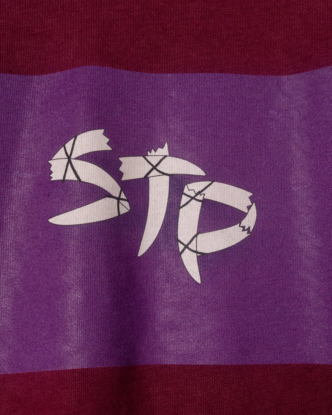 White logo on a purple and red striped background