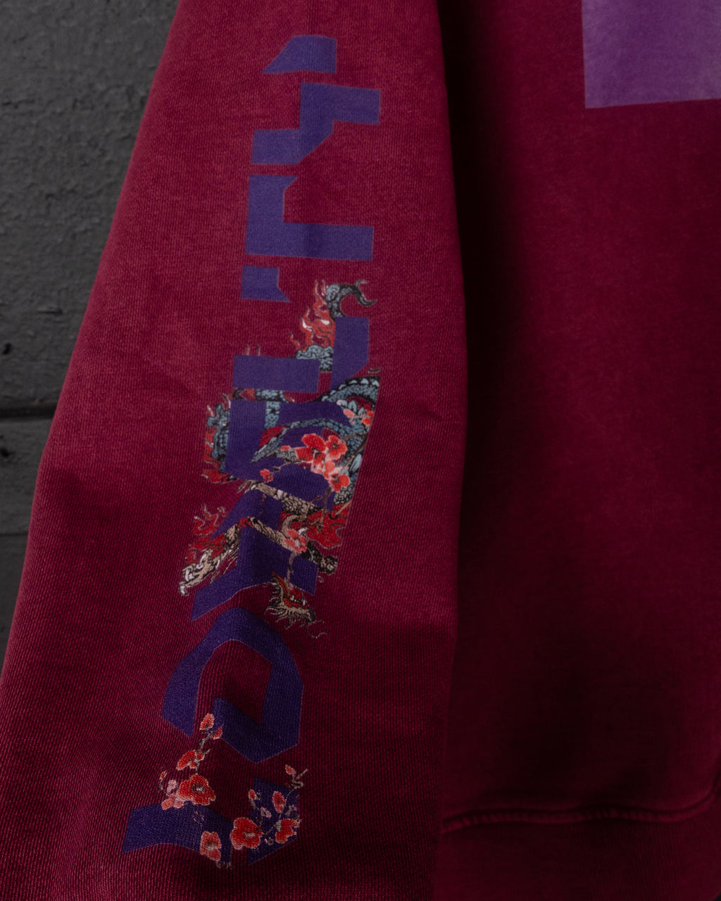 Red sweatshirt with a colorful graphic design on a dark background