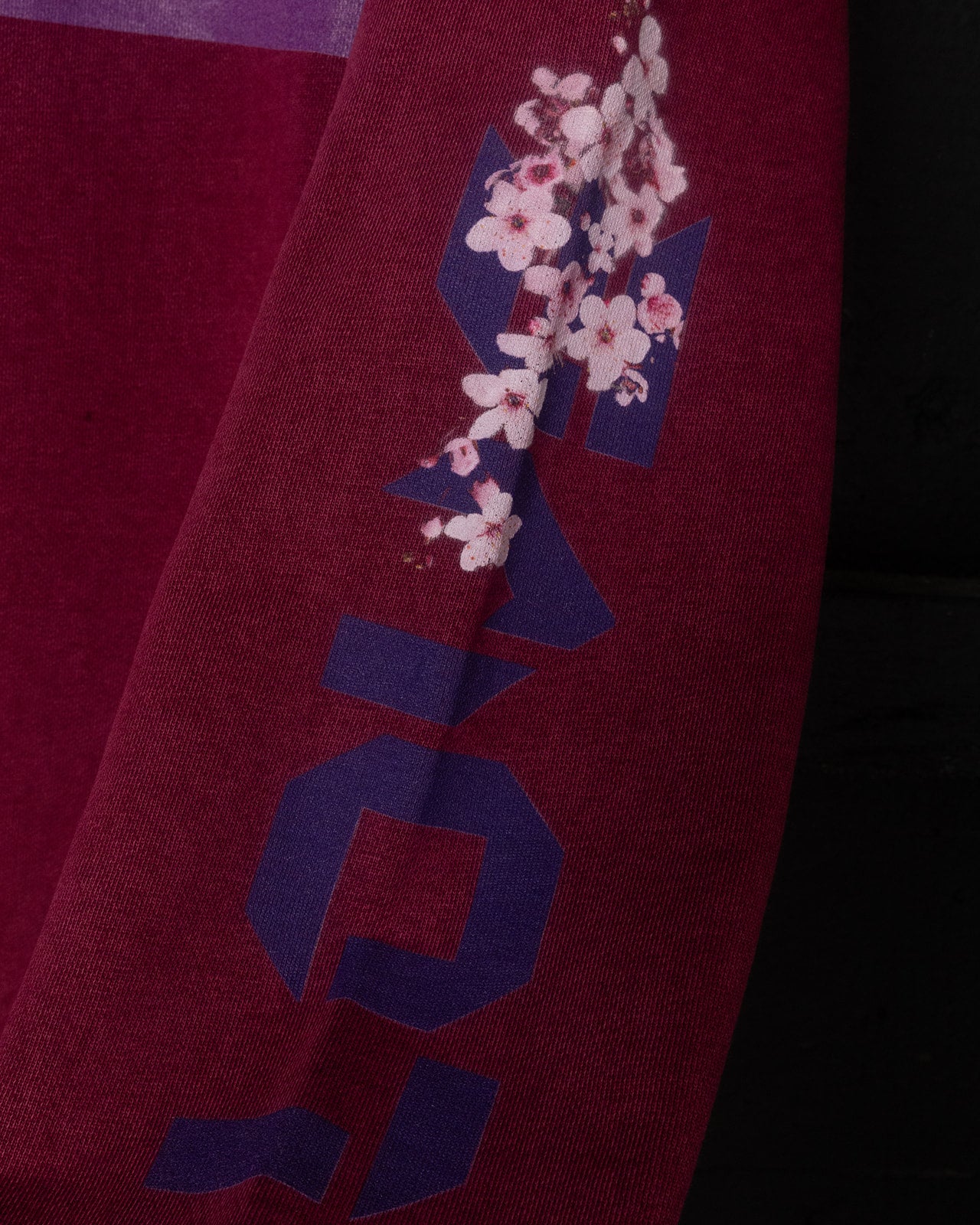 Red fabric with blue floral design on a dark background