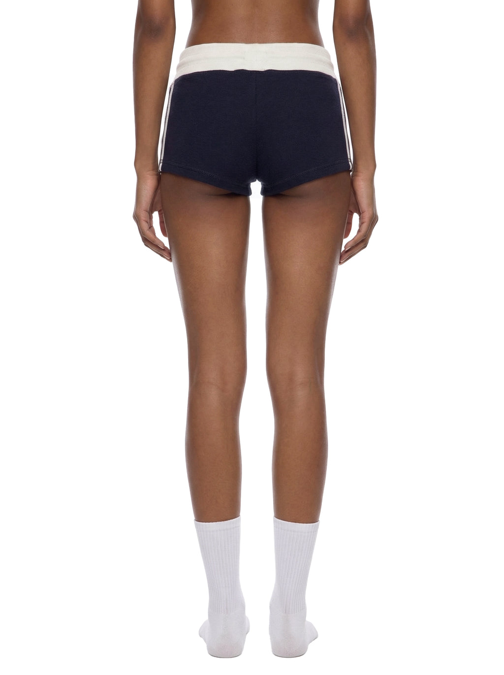 Person wearing navy shorts with white stripes on a white background