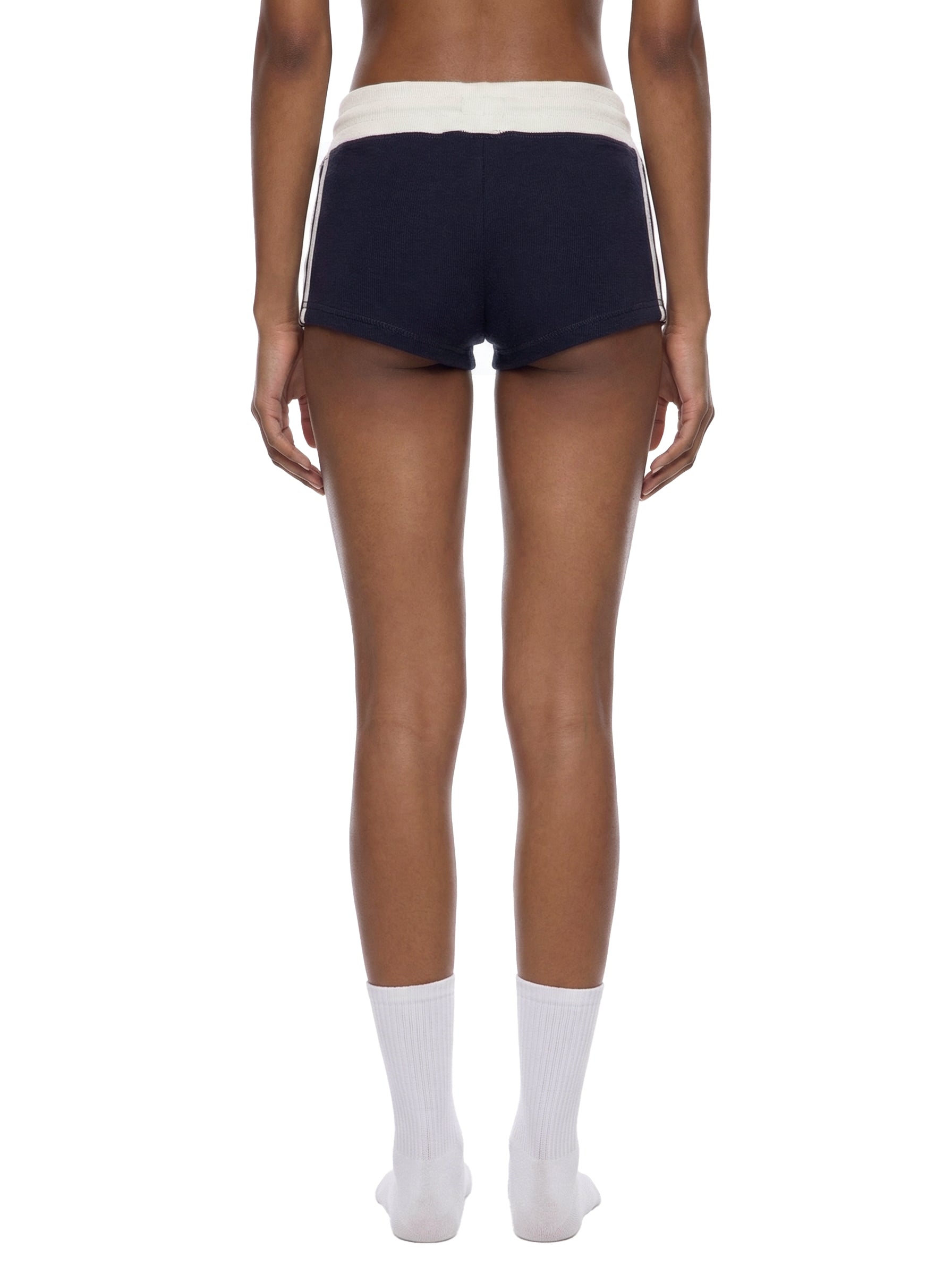 Person wearing navy shorts with white stripes on a white background