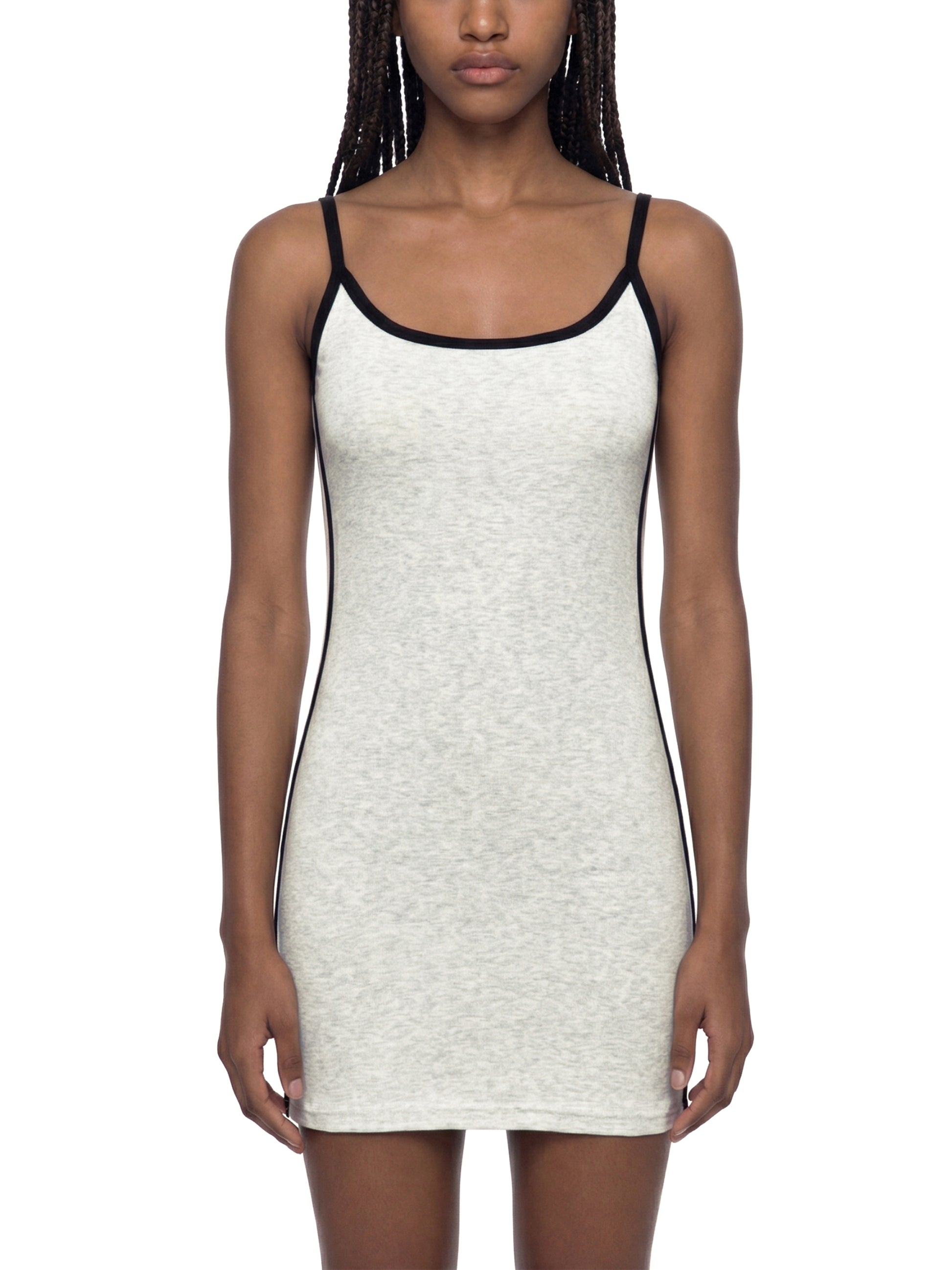 Woman wearing a white tank dress with black straps on a white background