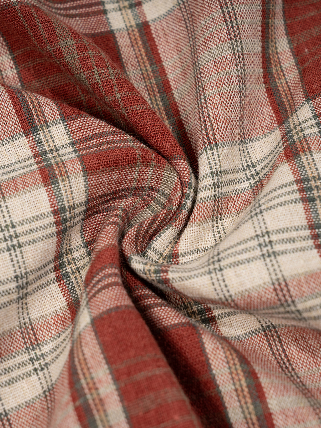 Close-up of plaid fabric with red, beige, and gray colors.
