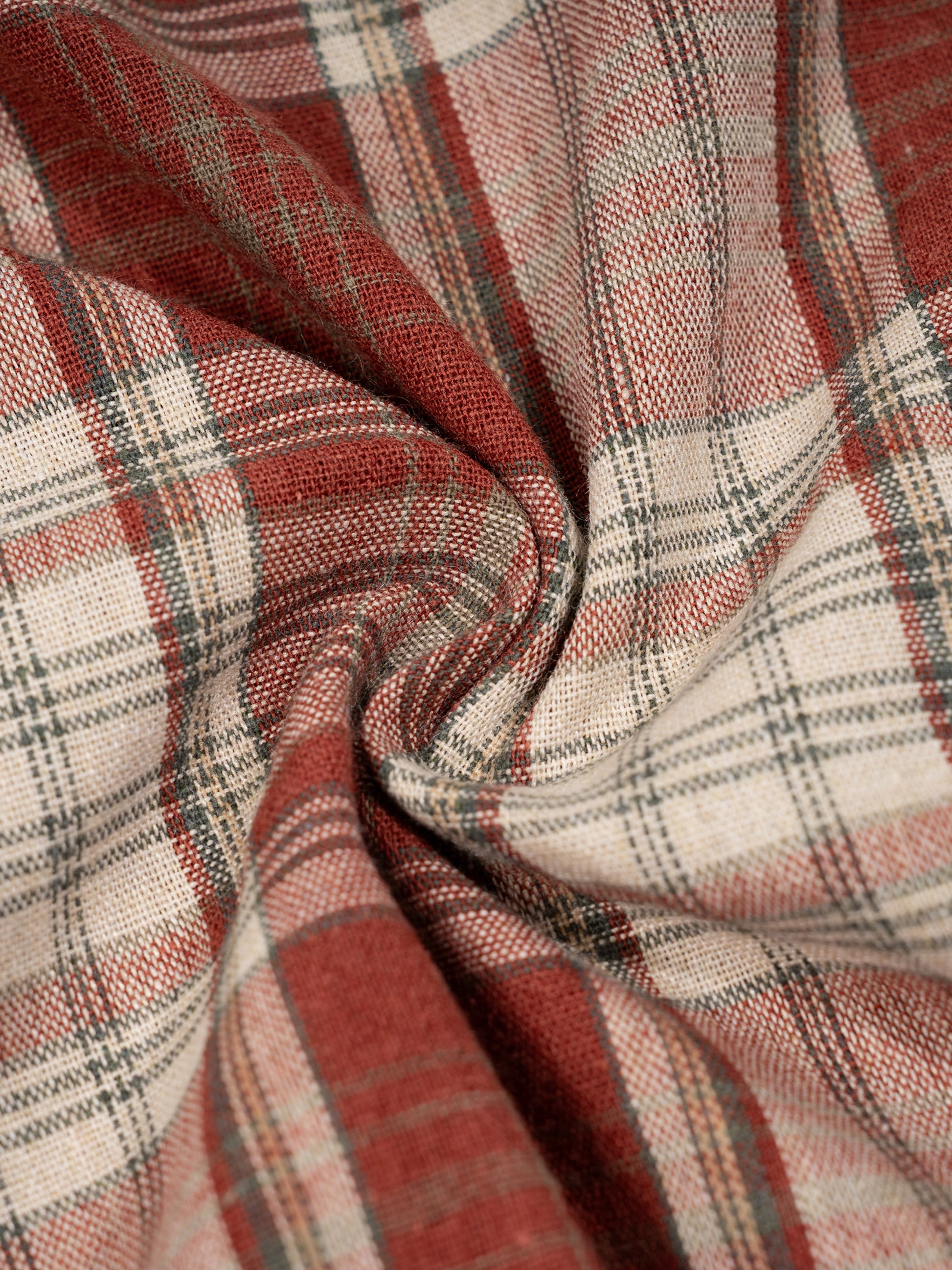 Close-up of plaid fabric with red, beige, and gray colors.