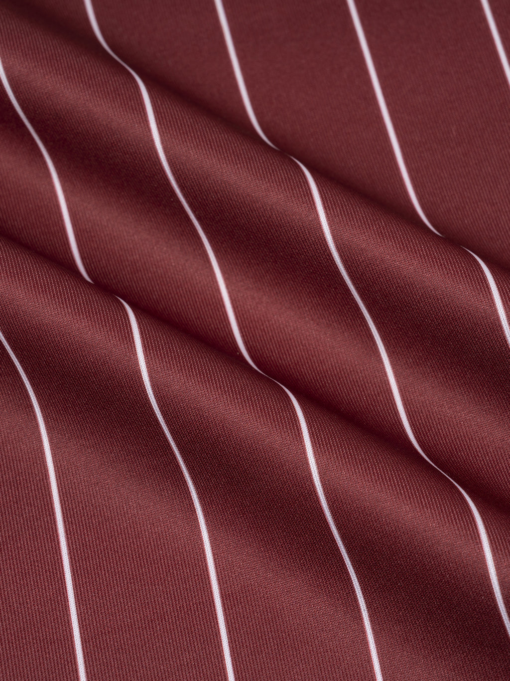 Close-up of maroon fabric with white vertical stripes