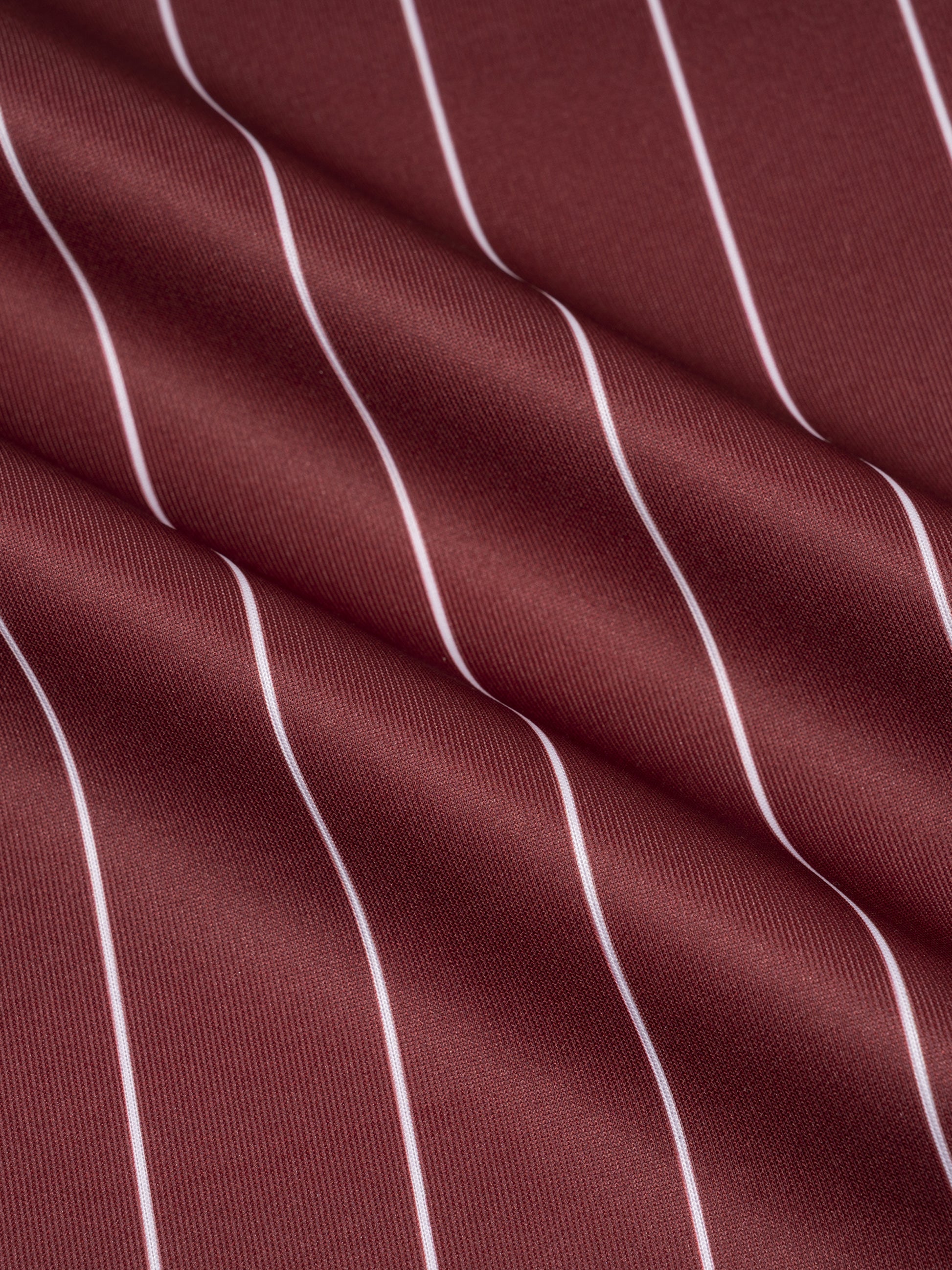 Close-up of maroon fabric with white vertical stripes