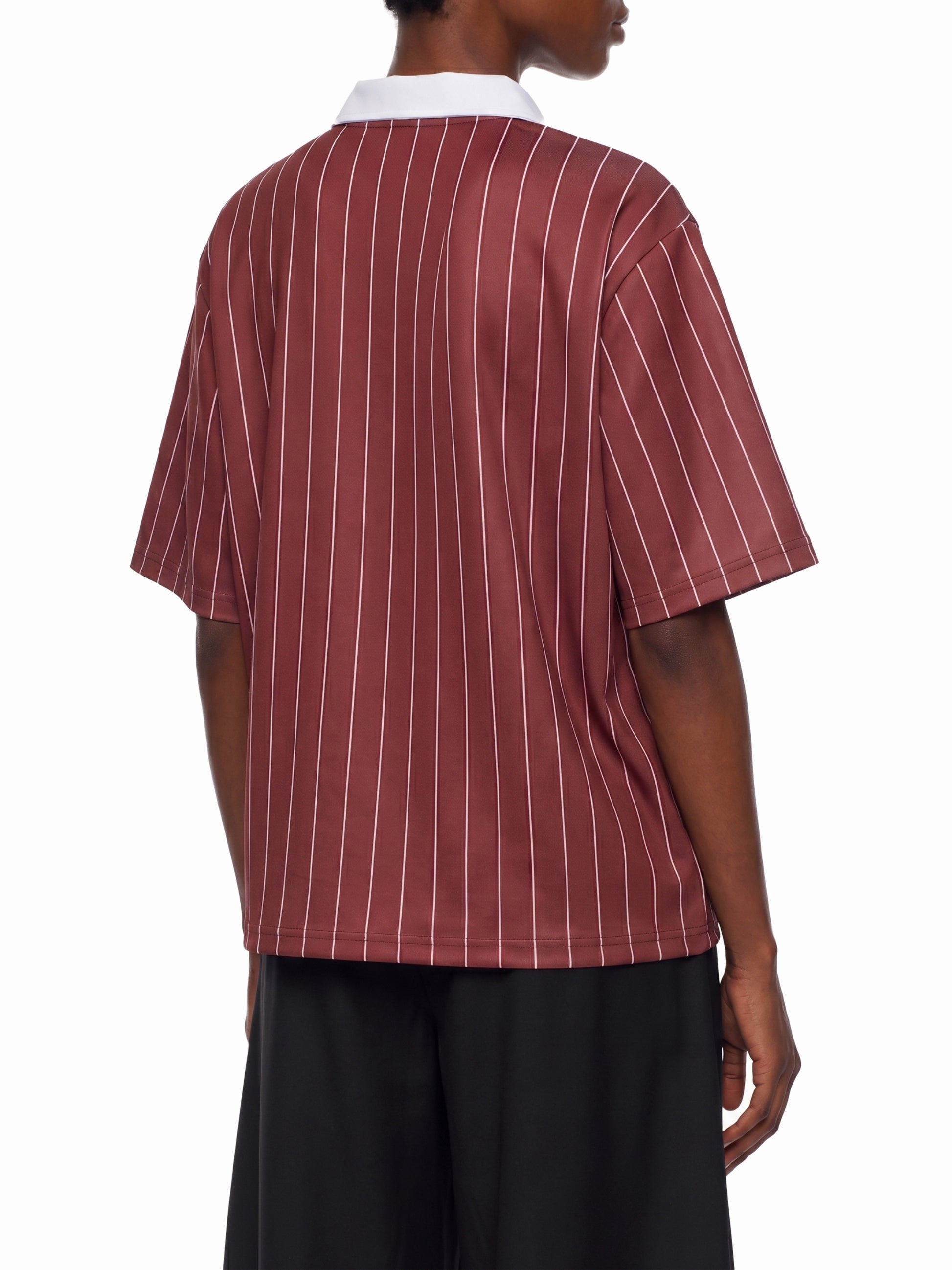 Person wearing a maroon and white striped shirt with a white collar on a white background