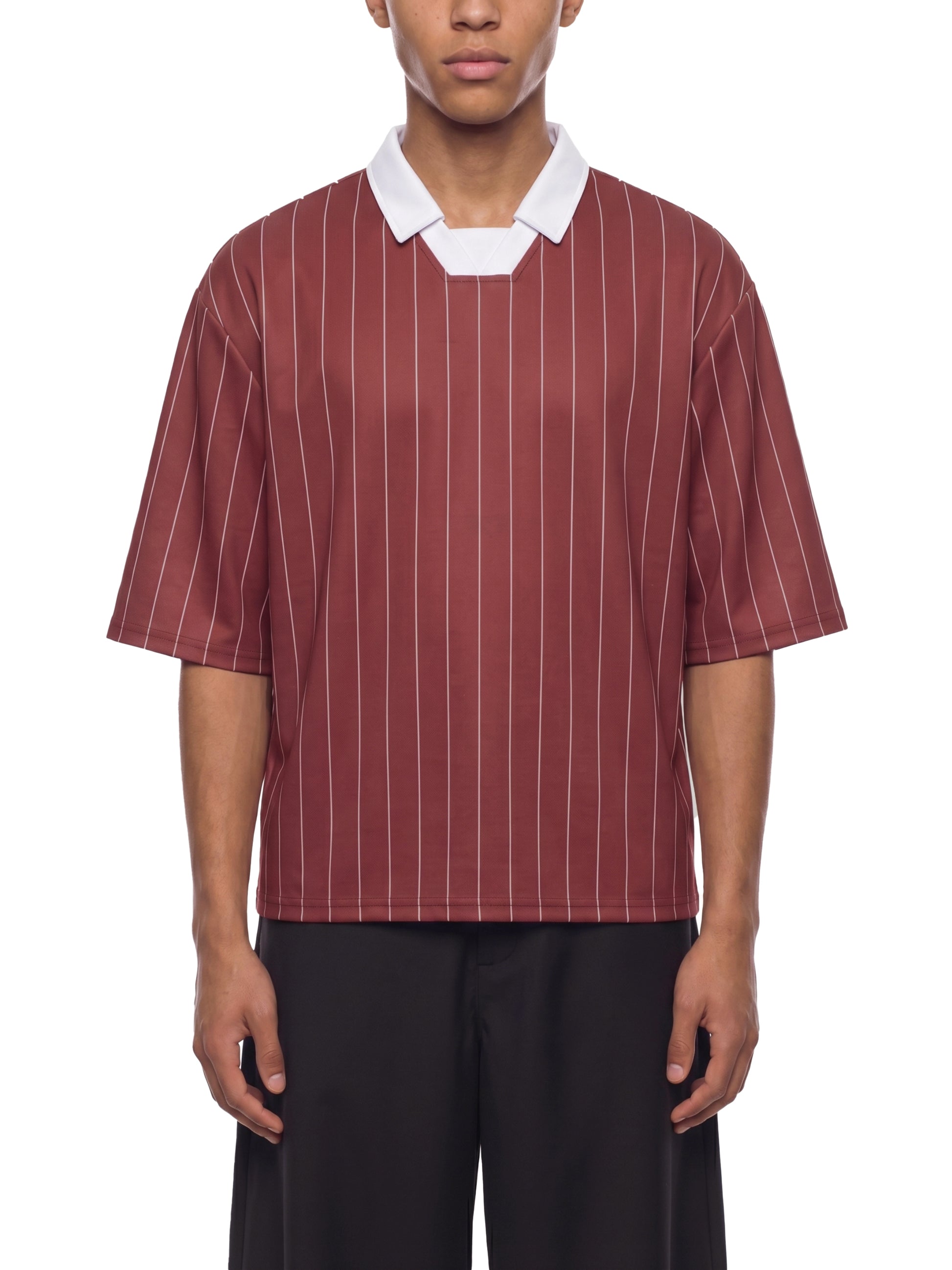Person wearing a maroon and white striped shirt with a white collar on a white background
