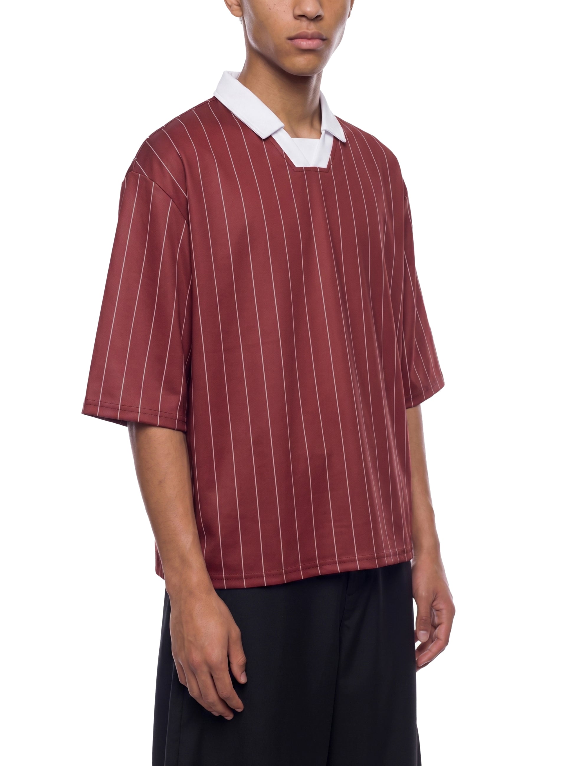Person wearing a maroon and white striped shirt with a white collar on a white background