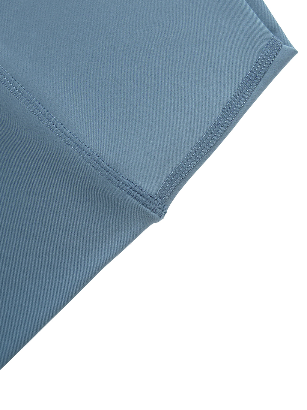 Close-up of a blue fabric with stitching detail on a white background