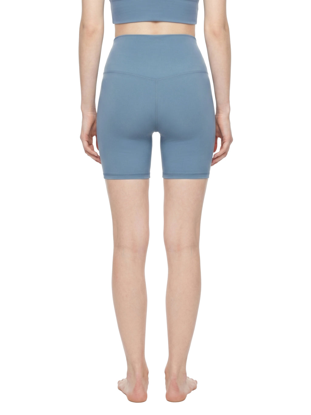 Person wearing blue high-waisted shorts on a white background