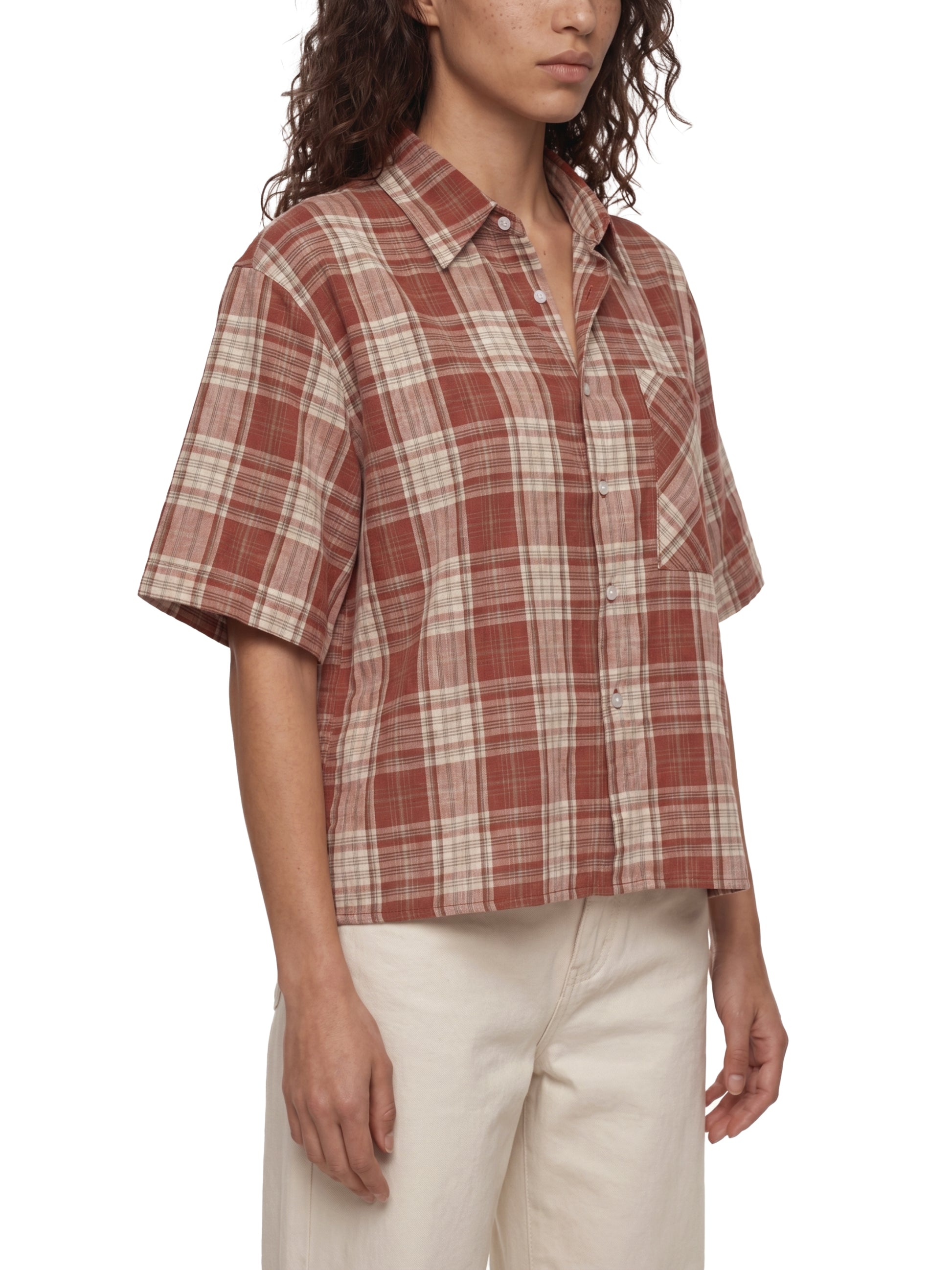 Woman wearing a plaid shirt with a white background