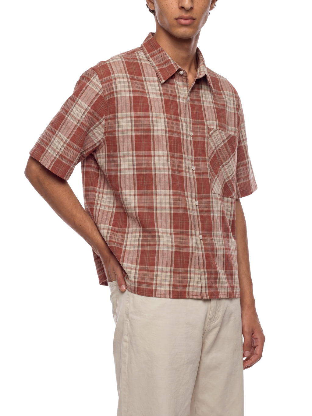 Person wearing a plaid shirt with short sleeves on a white background