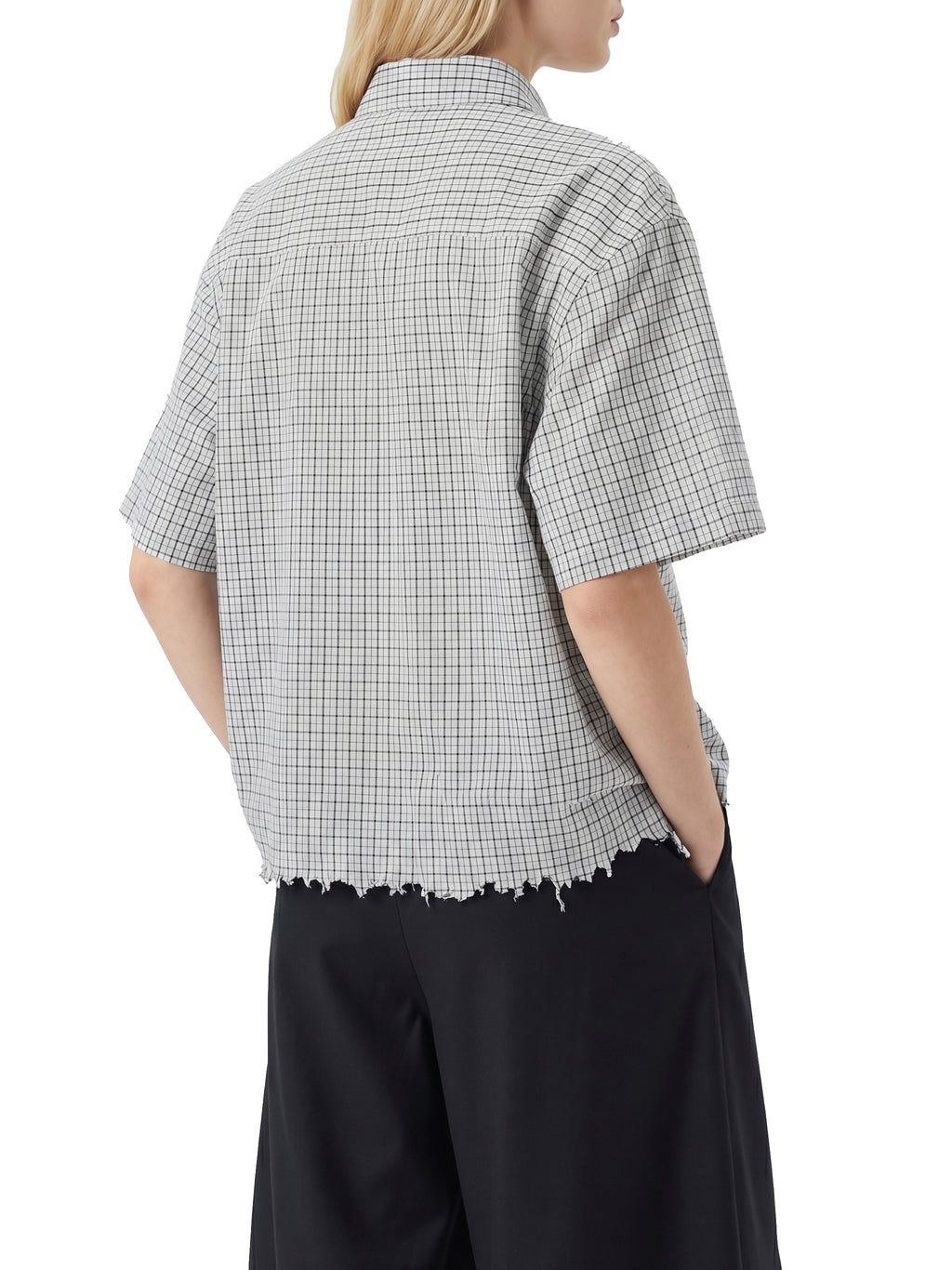 Person wearing a checkered shirt with short sleeves on a white background