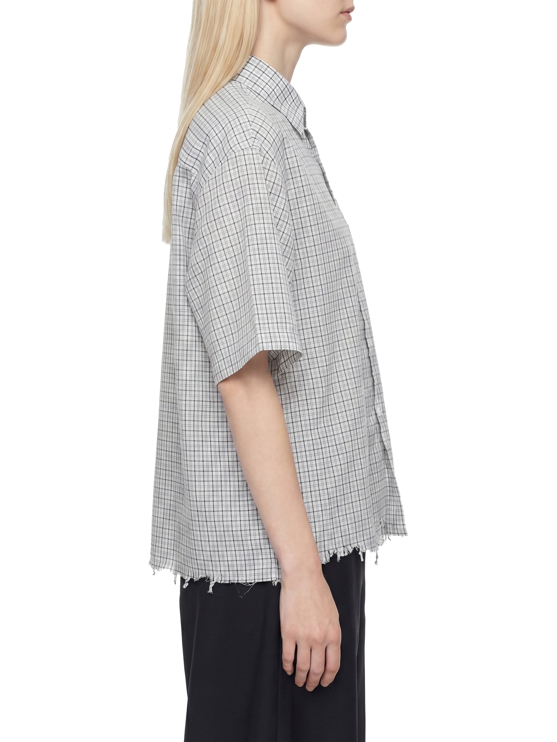 Person wearing a checkered shirt with a white background