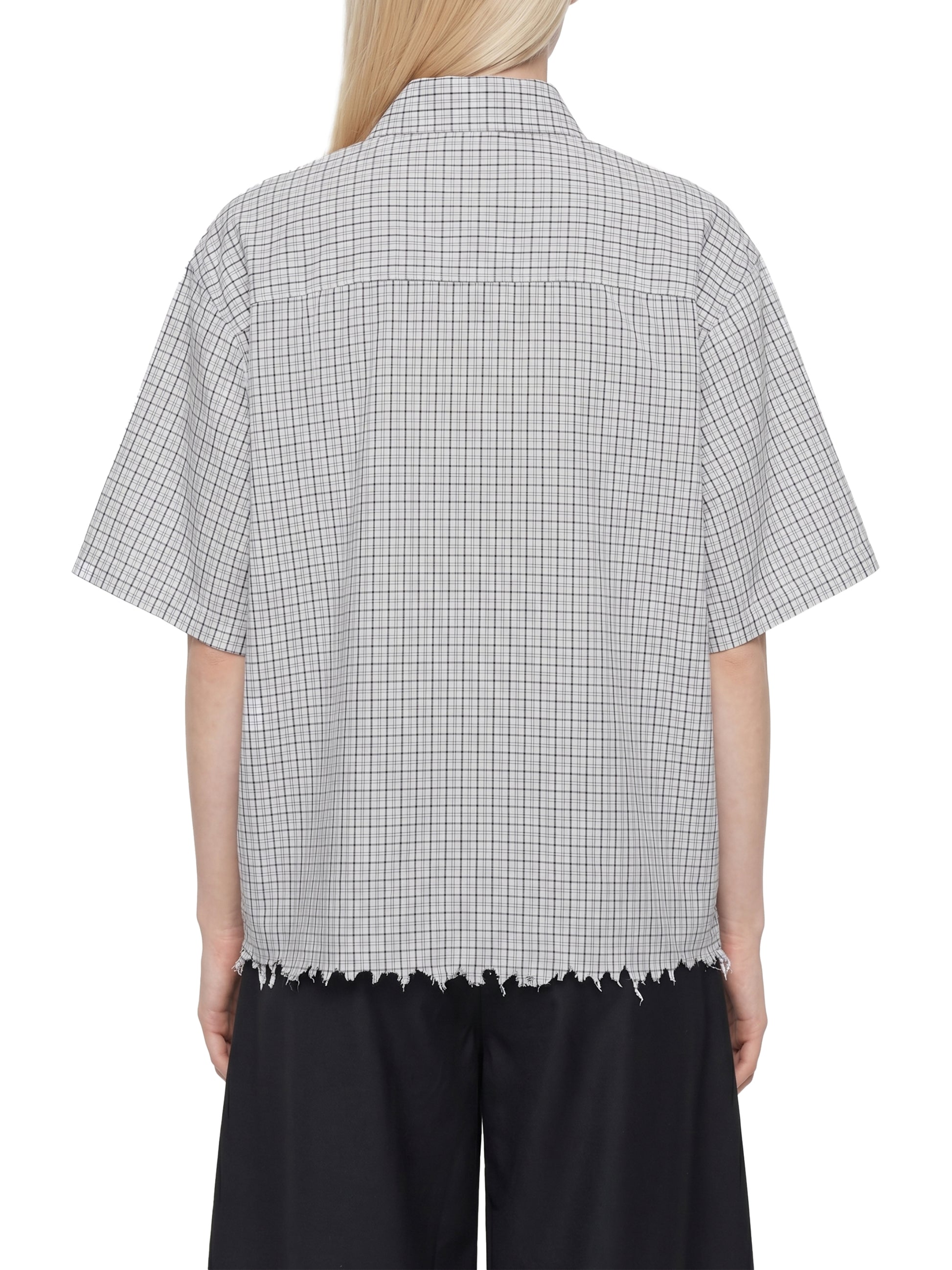 Person wearing a checkered shirt with a white background
