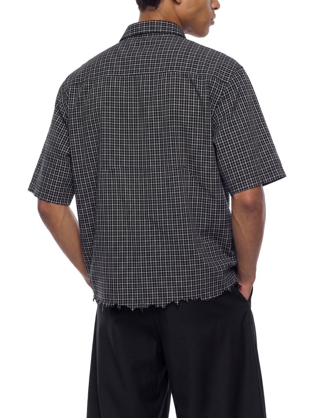 Person wearing a black and white checkered shirt on a white background