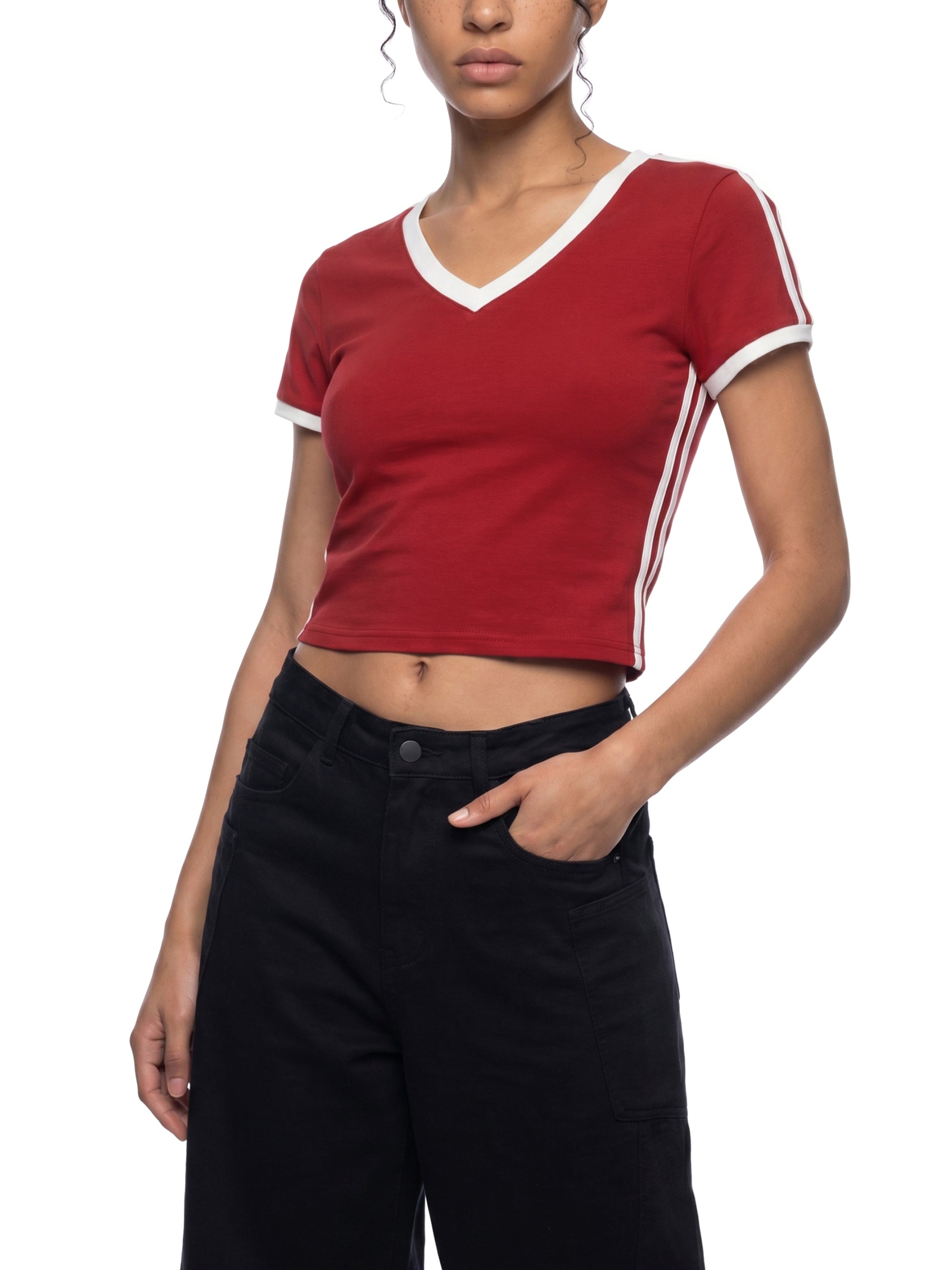 Person wearing a red crop top with white trim and black pants on a white background