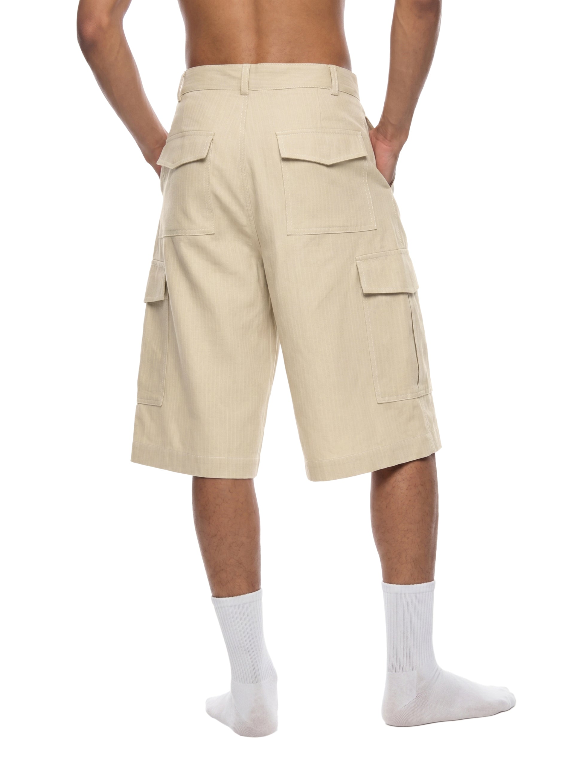 Beige cargo shorts worn by a person on a white background