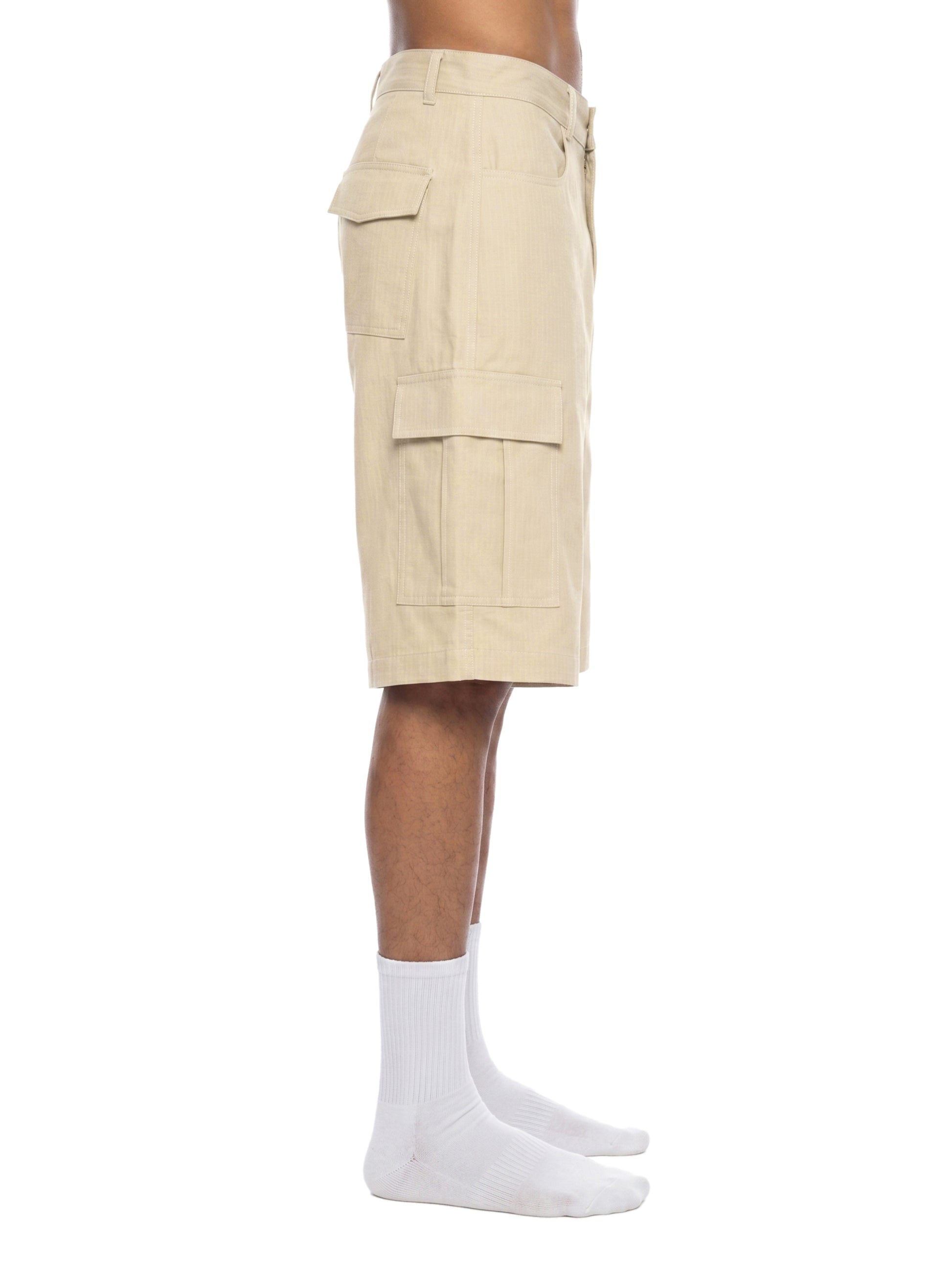 Beige cargo shorts worn by a person on a white background