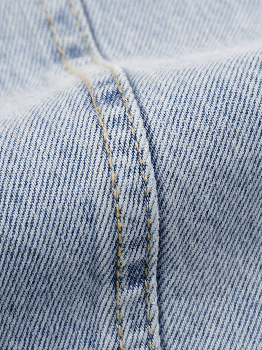 Close-up of blue denim fabric with stitching detail