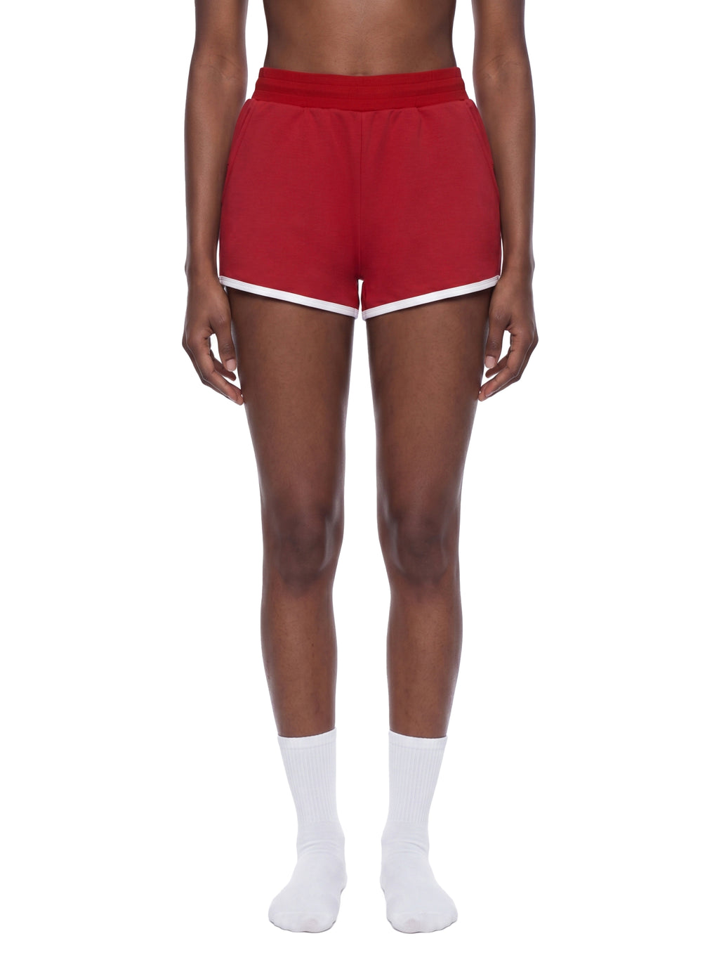 Red shorts with white trim worn by a person on a white background