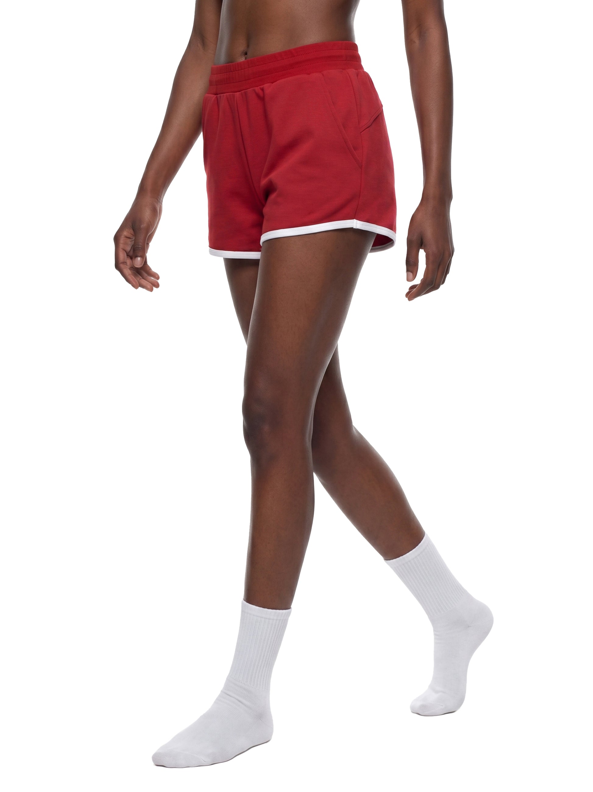 Person wearing red shorts and white socks on a white background